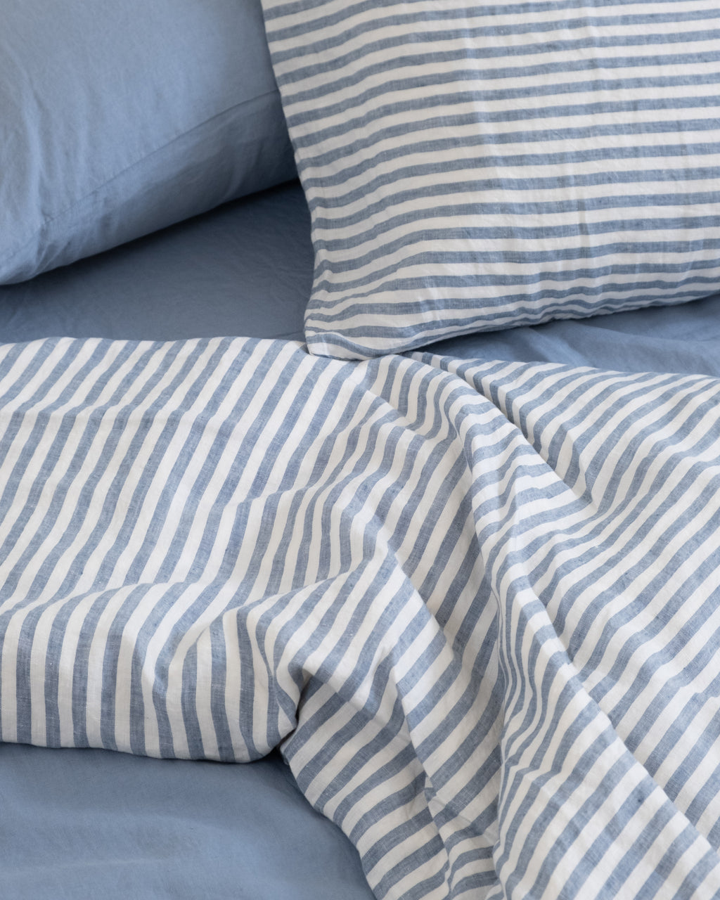 מצעי פשתן כחולים עם ציפה וציפיות בדוגמת פסים כחולים, עשויים מ־100% פשתן צרפתי מרוכך של HOMI
